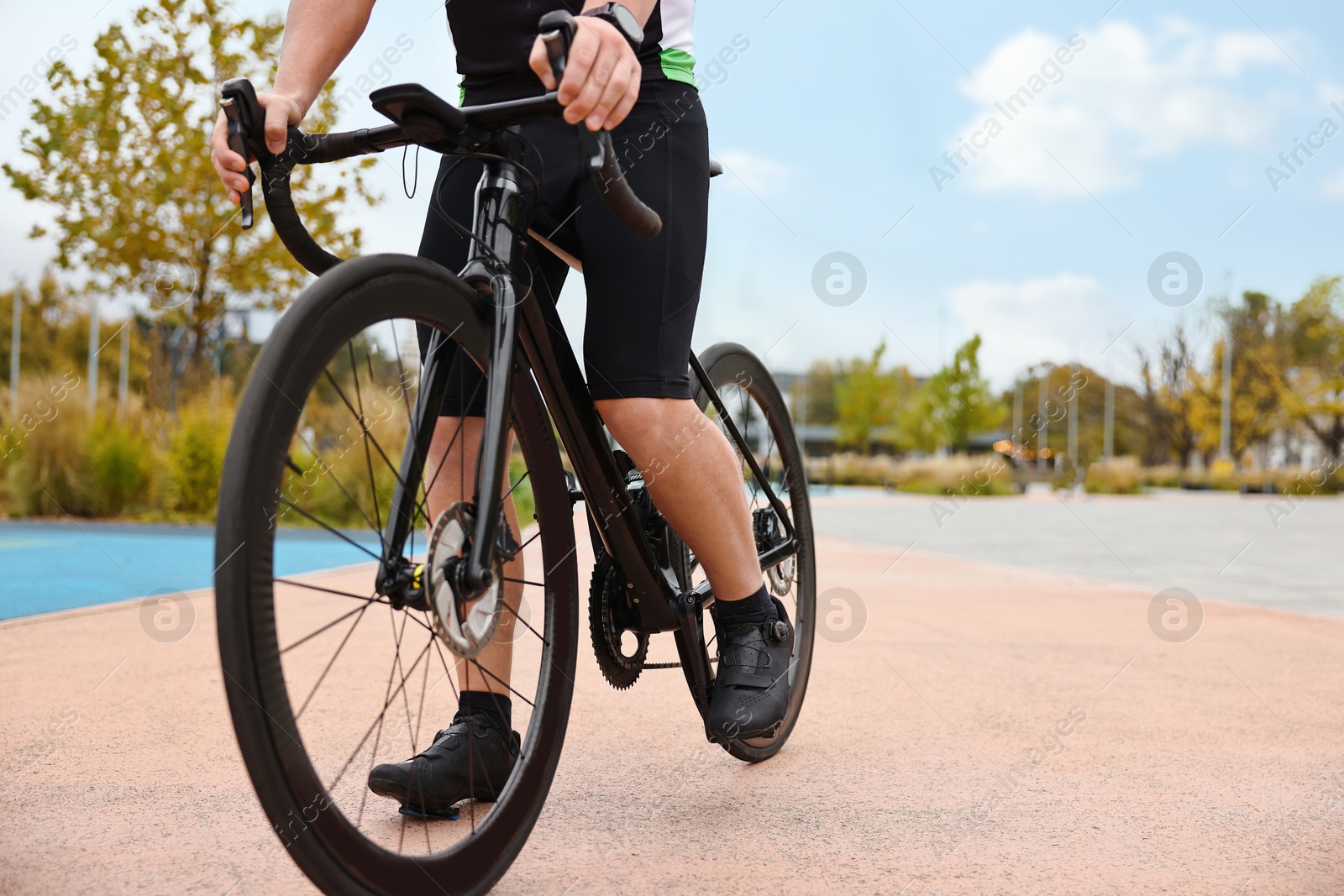 Photo of Athletic man with bicycle outdoors, closeup. Space for text