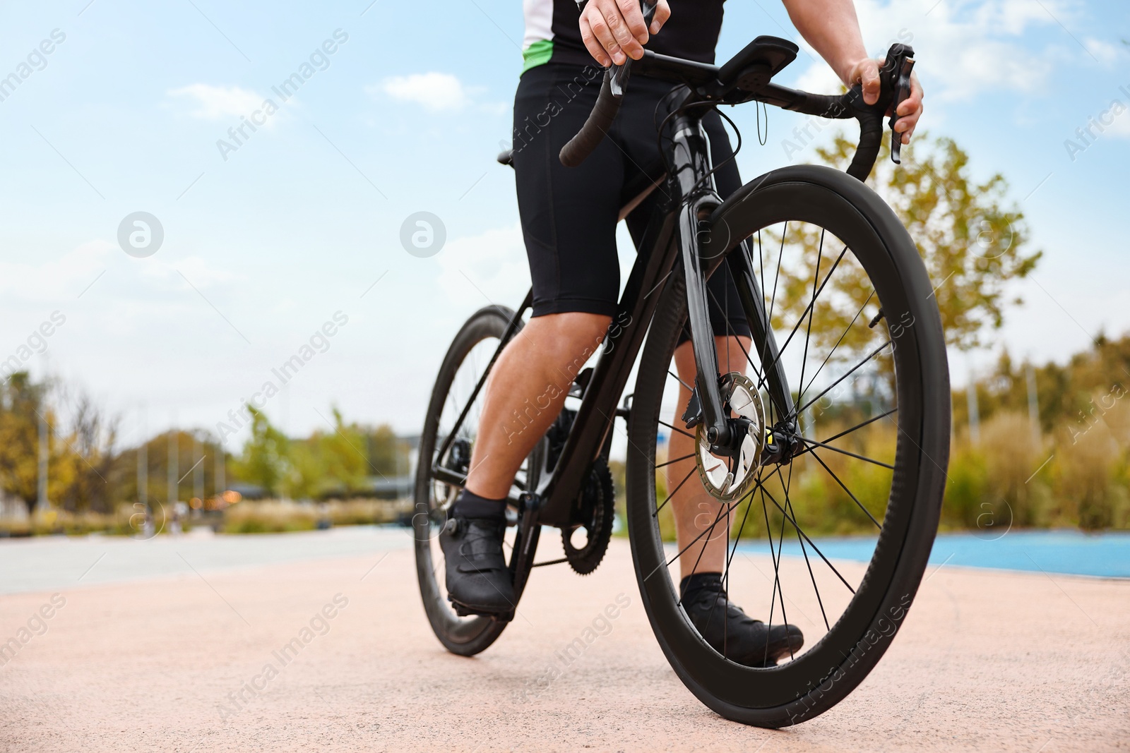 Photo of Athletic man with bicycle outdoors, closeup. Space for text