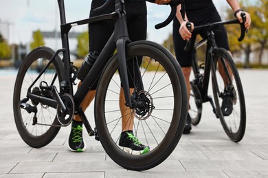 Photo of Athletic men with bicycles outdoors, closeup view