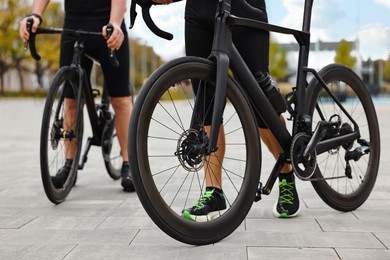 Photo of Athletic men with bicycles outdoors, closeup view