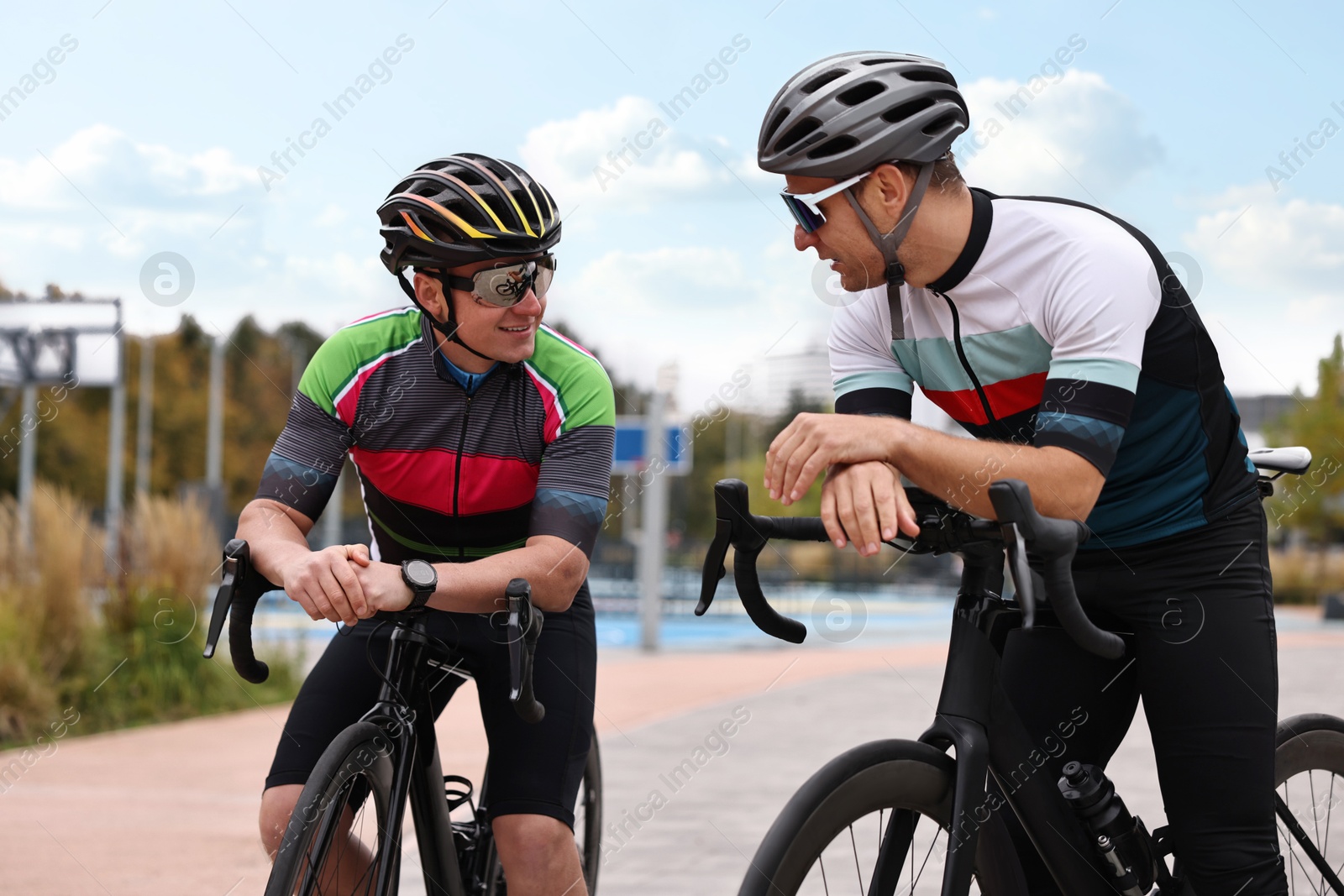 Photo of Athletic men with helmets and bicycles outdoors