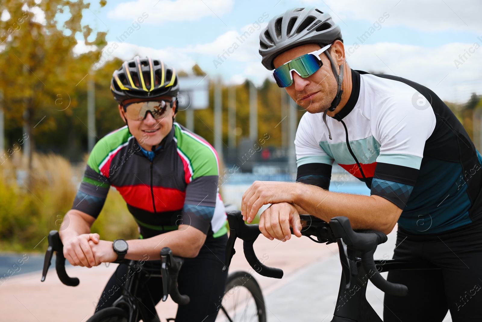 Photo of Athletic men with helmets and bicycles outdoors