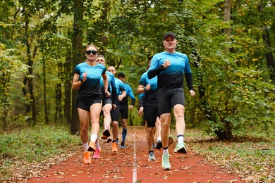 Photo of Group of athletic people running in park