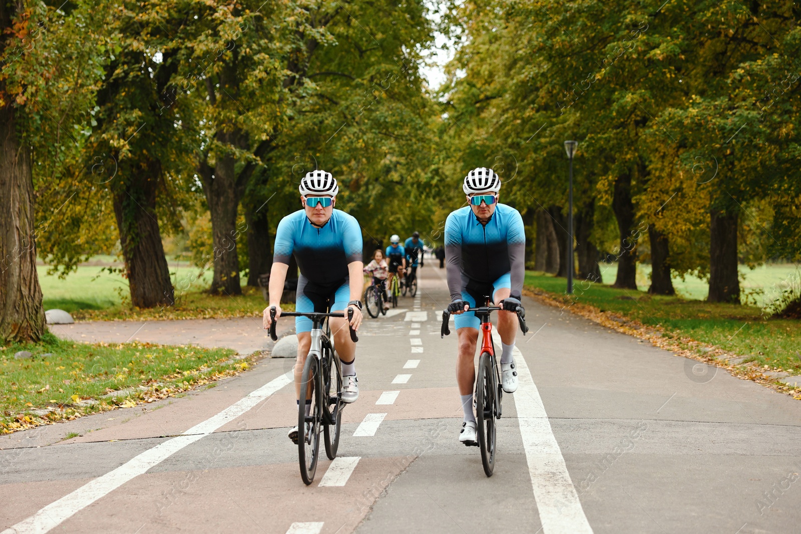 Photo of Group of athletic people riding bicycles outdoors