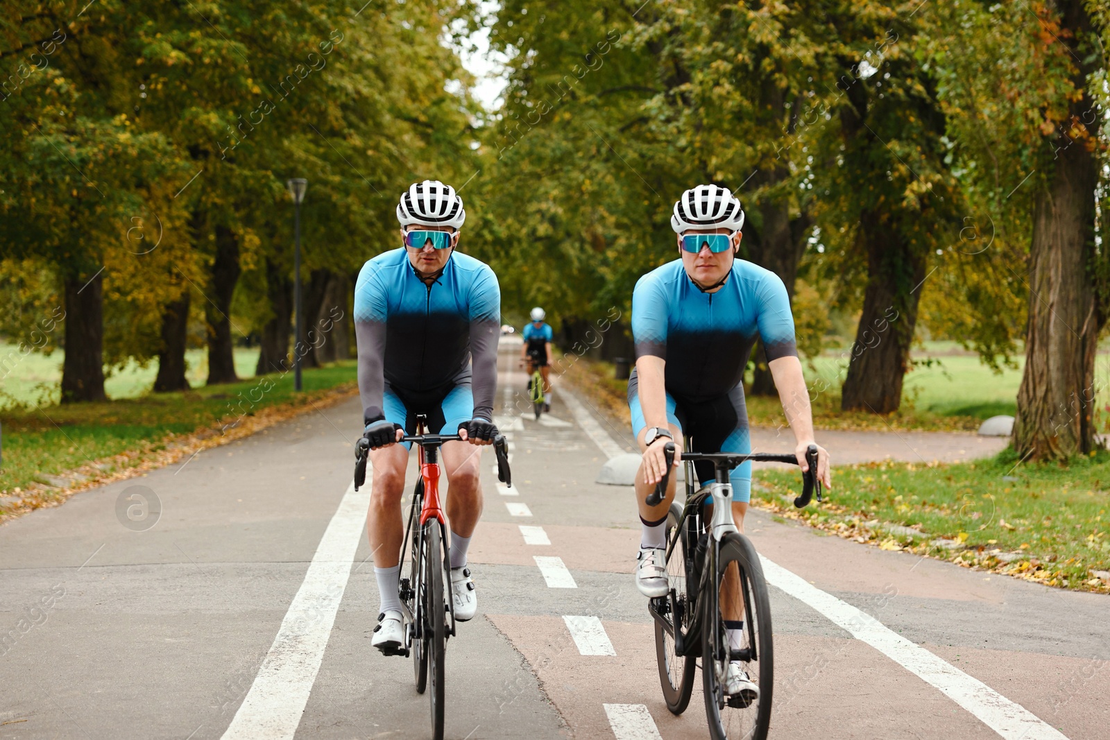 Photo of Group of athletic people riding bicycles outdoors