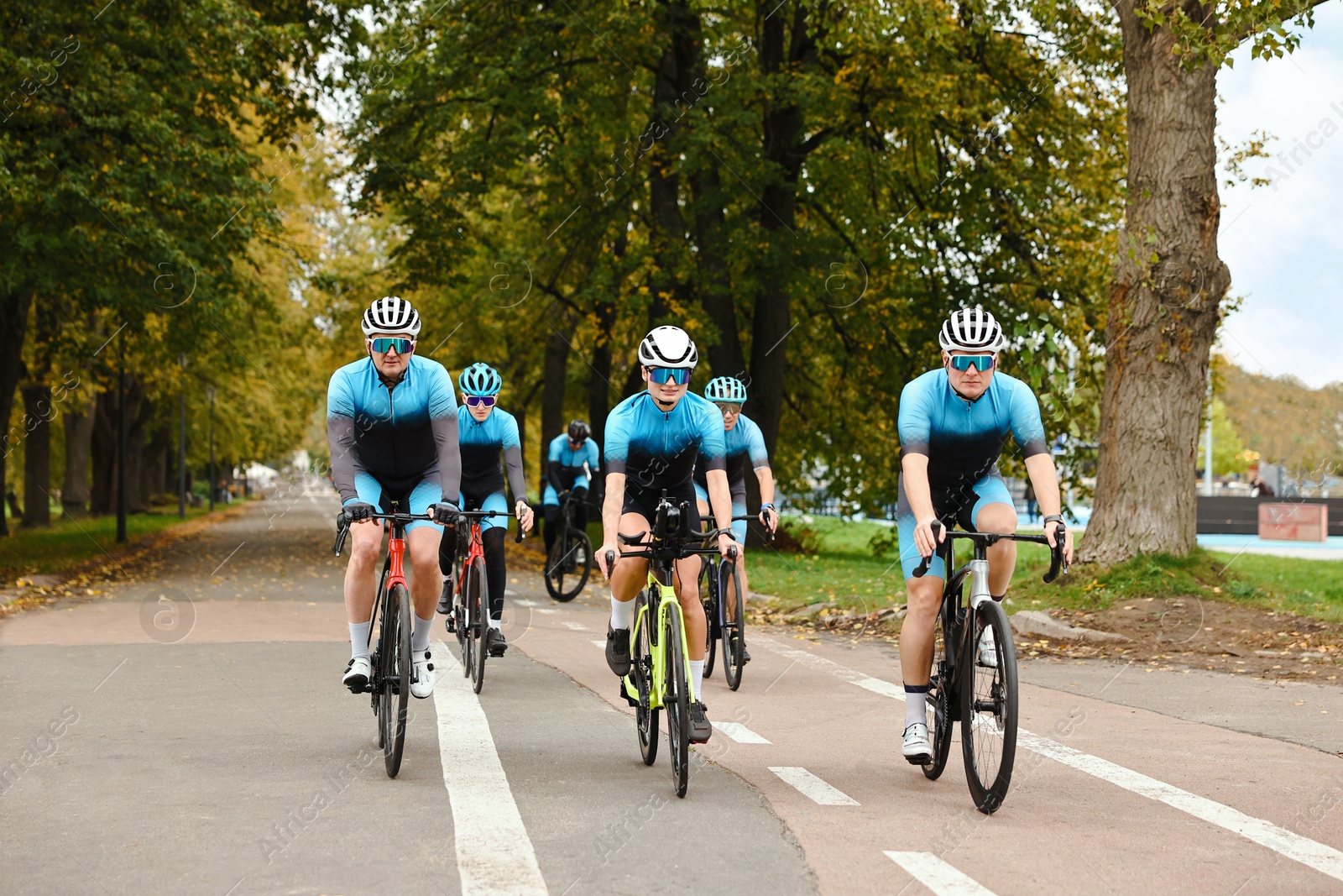 Photo of Group of athletic people riding bicycles outdoors