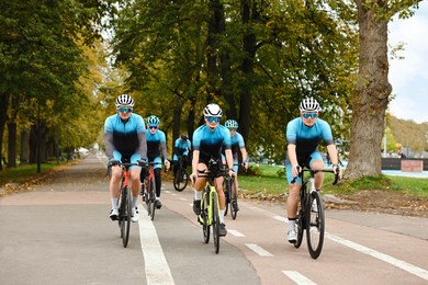 Photo of Group of athletic people riding bicycles outdoors