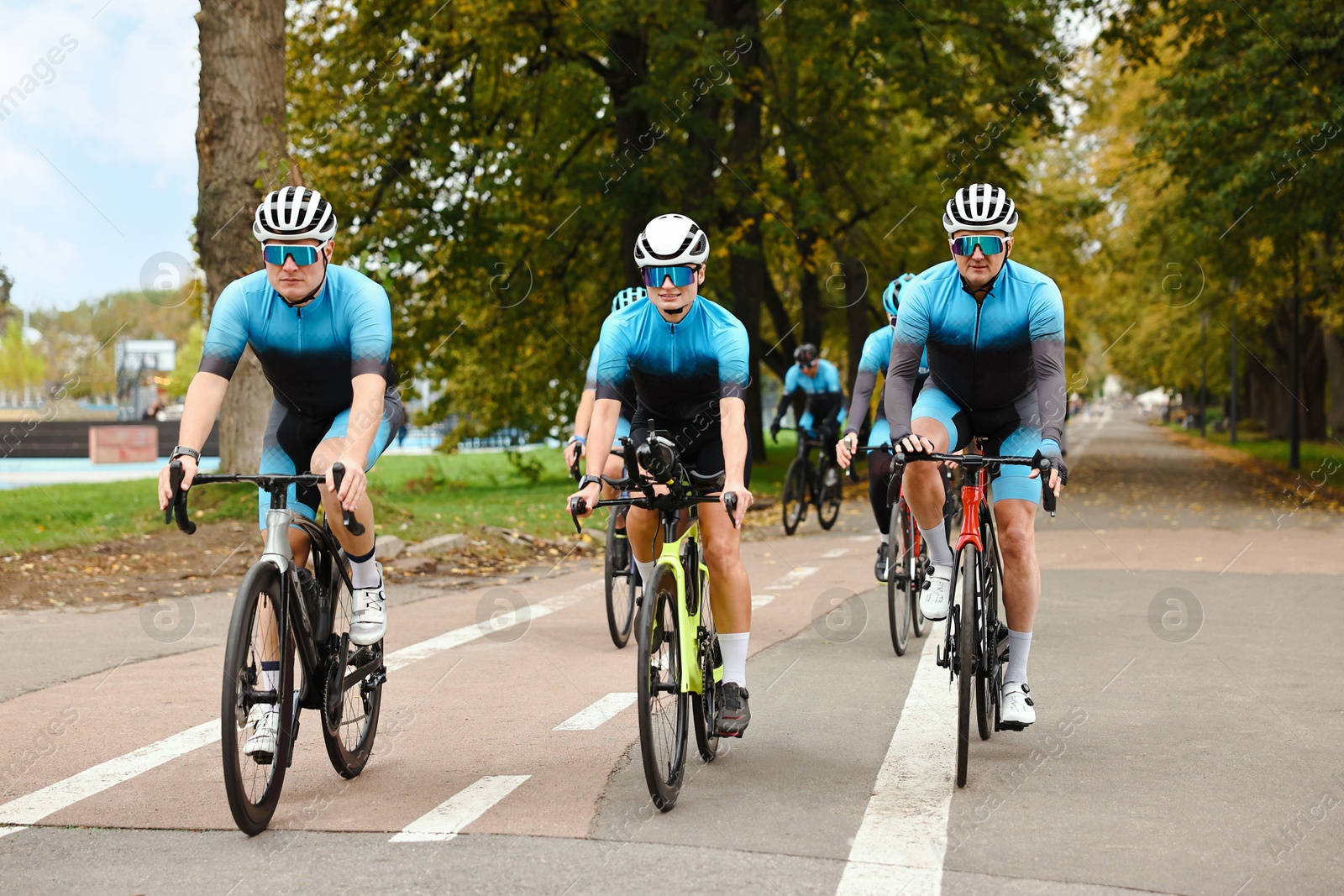 Photo of Group of athletic people riding bicycles outdoors