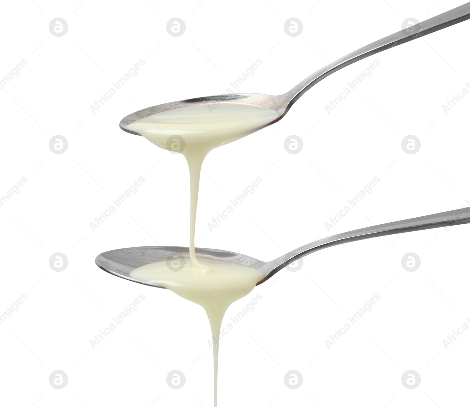 Photo of Condensed milk flowing down from spoons isolated on white