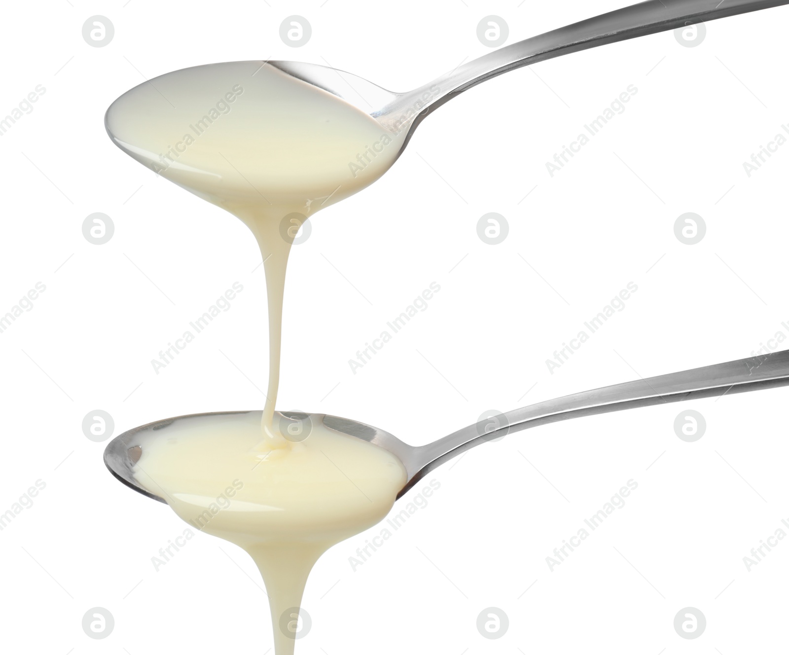 Photo of Condensed milk flowing down from spoons isolated on white