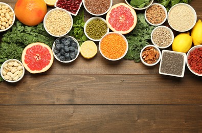 Photo of Superfood. Different healthy food products on wooden table, flat lay. Space for text