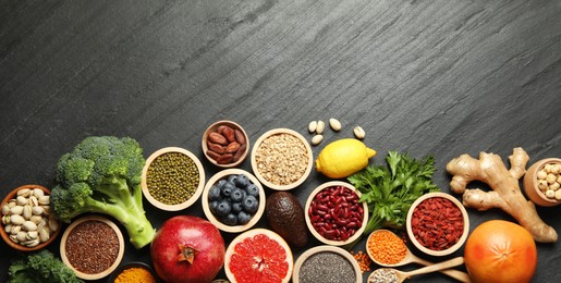 Photo of Superfood. Different healthy food products on grey table, flat lay. Space for text