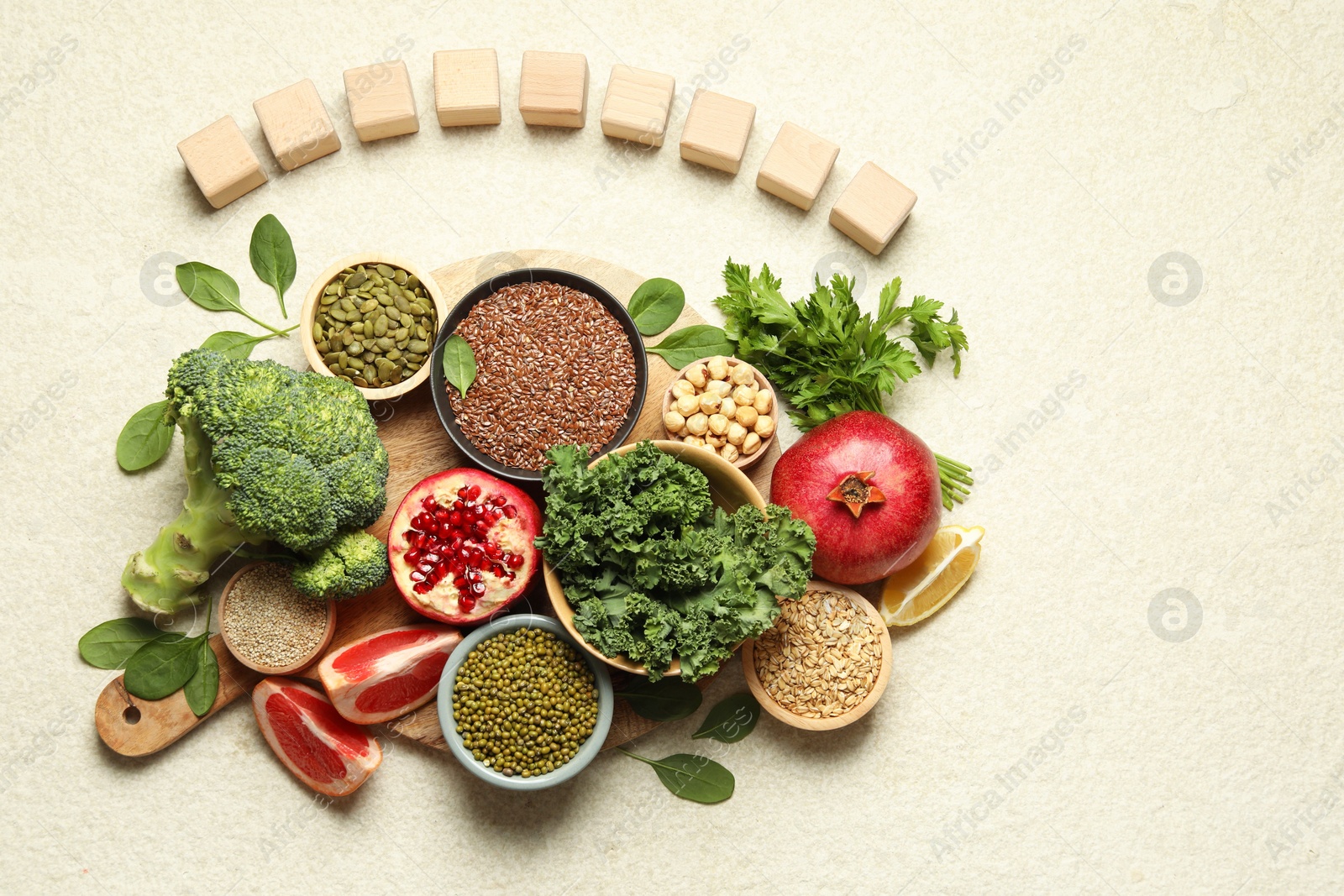 Photo of Different superfood products and blank cubes on light table, top view. Space for text