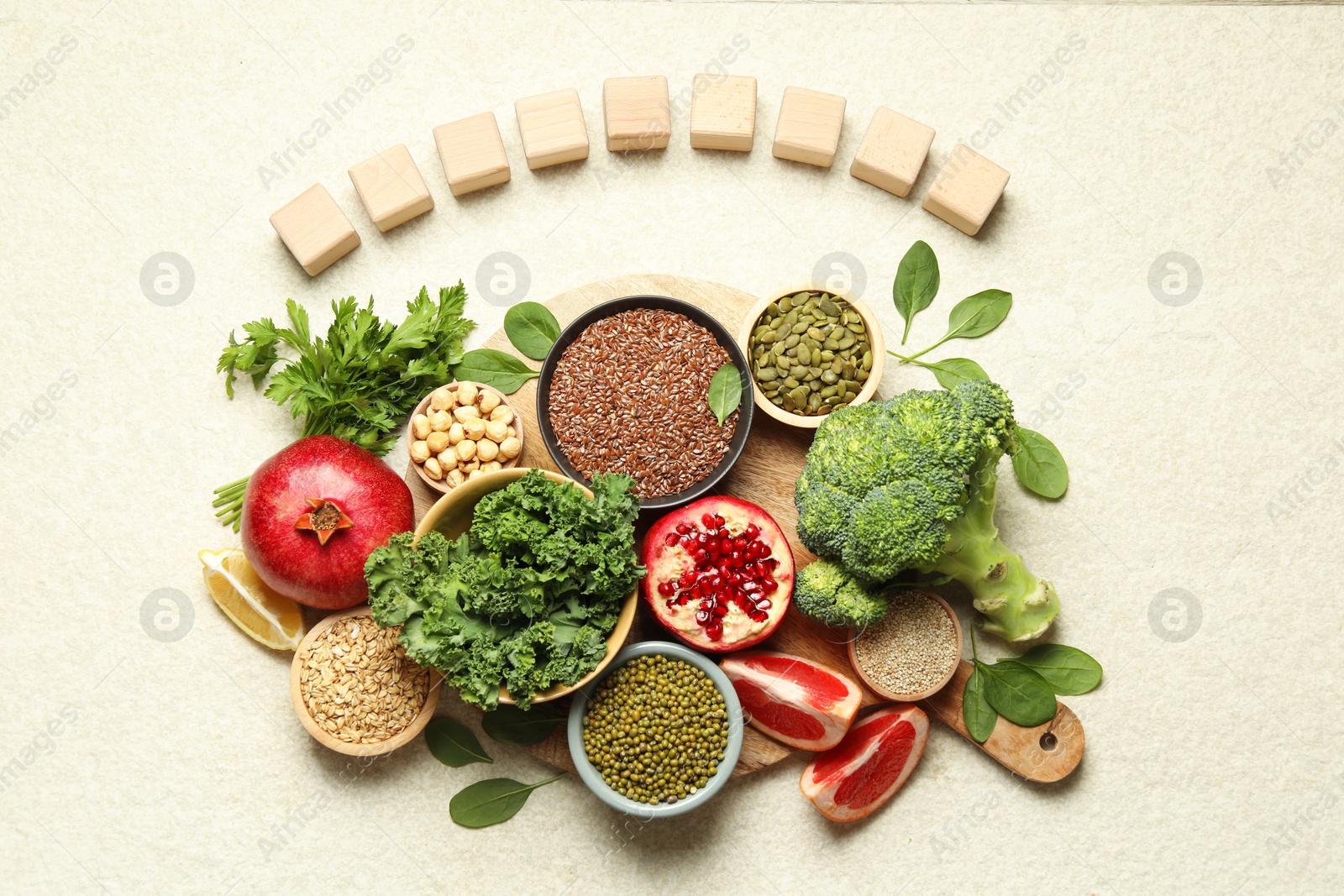 Photo of Different superfood products and blank cubes on light table, top view. Space for text