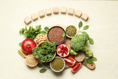 Photo of Different superfood products and blank cubes on light table, top view. Space for text