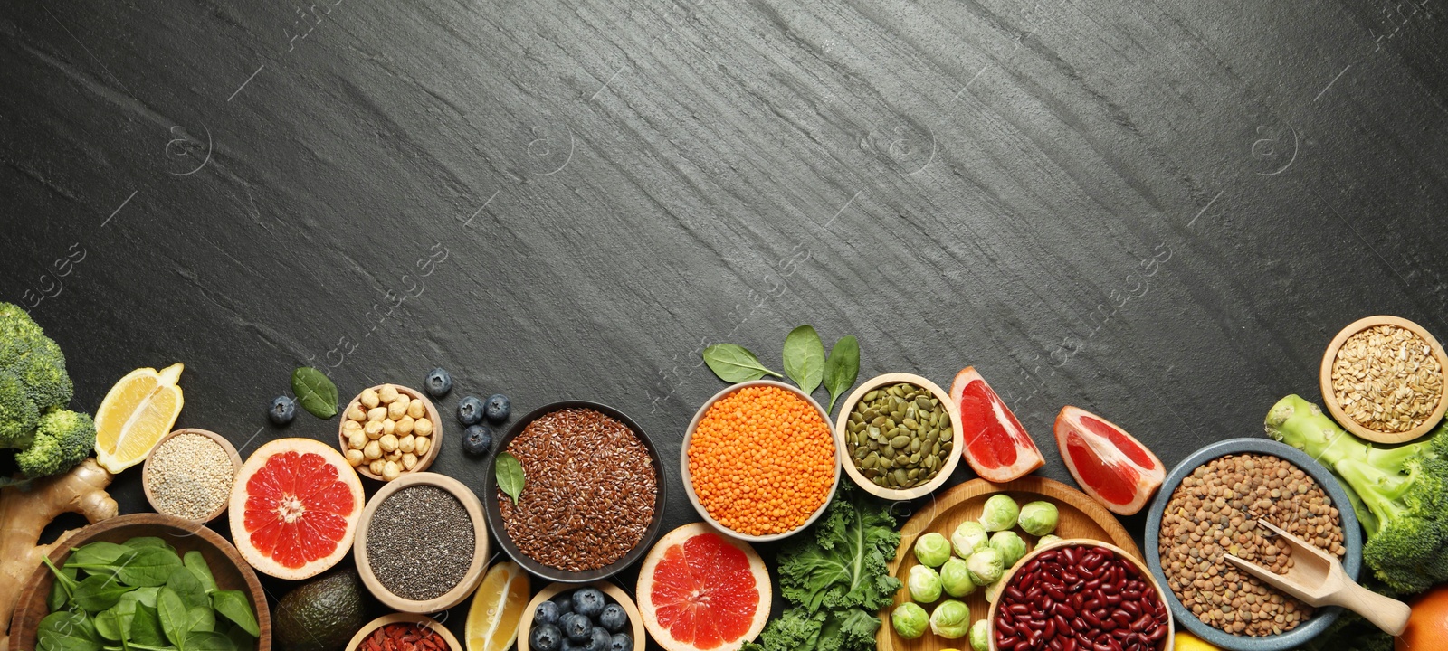 Photo of Different superfood products on black table, flat lay. Space for text