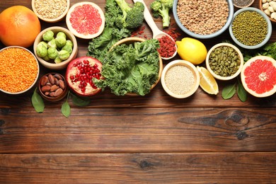 Photo of Different superfood products on wooden table, flat lay. Space for text