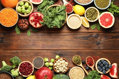 Photo of Different superfood products on wooden table, flat lay. Space for text