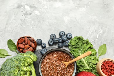 Photo of Different superfood products on grey table, flat lay. Space for text