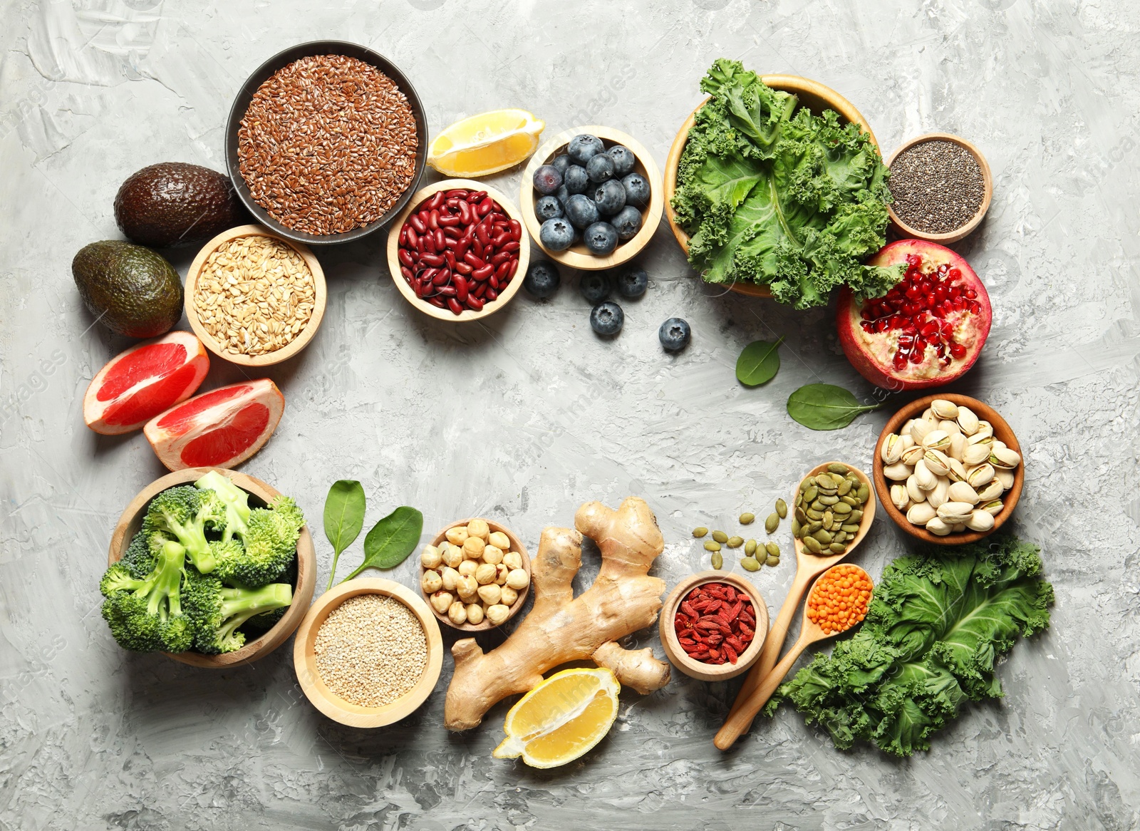 Photo of Frame of different superfood products on grey table, flat lay. Space for text