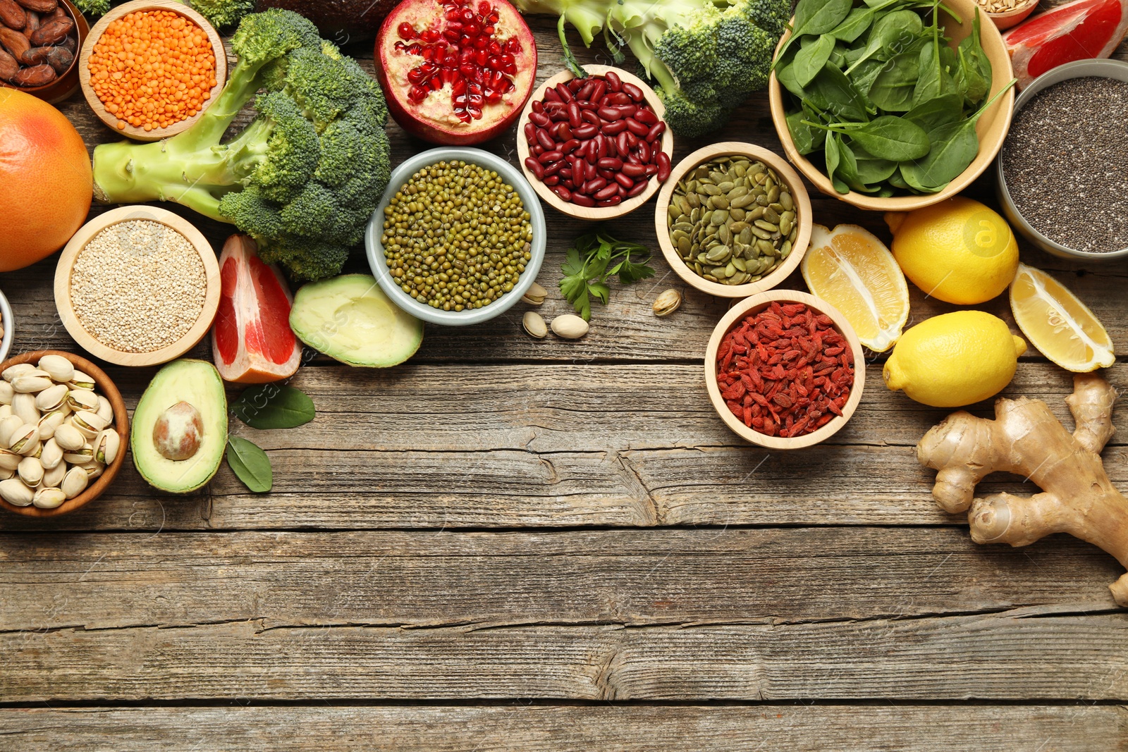 Photo of Different superfood products on wooden table, flat lay. Space for text