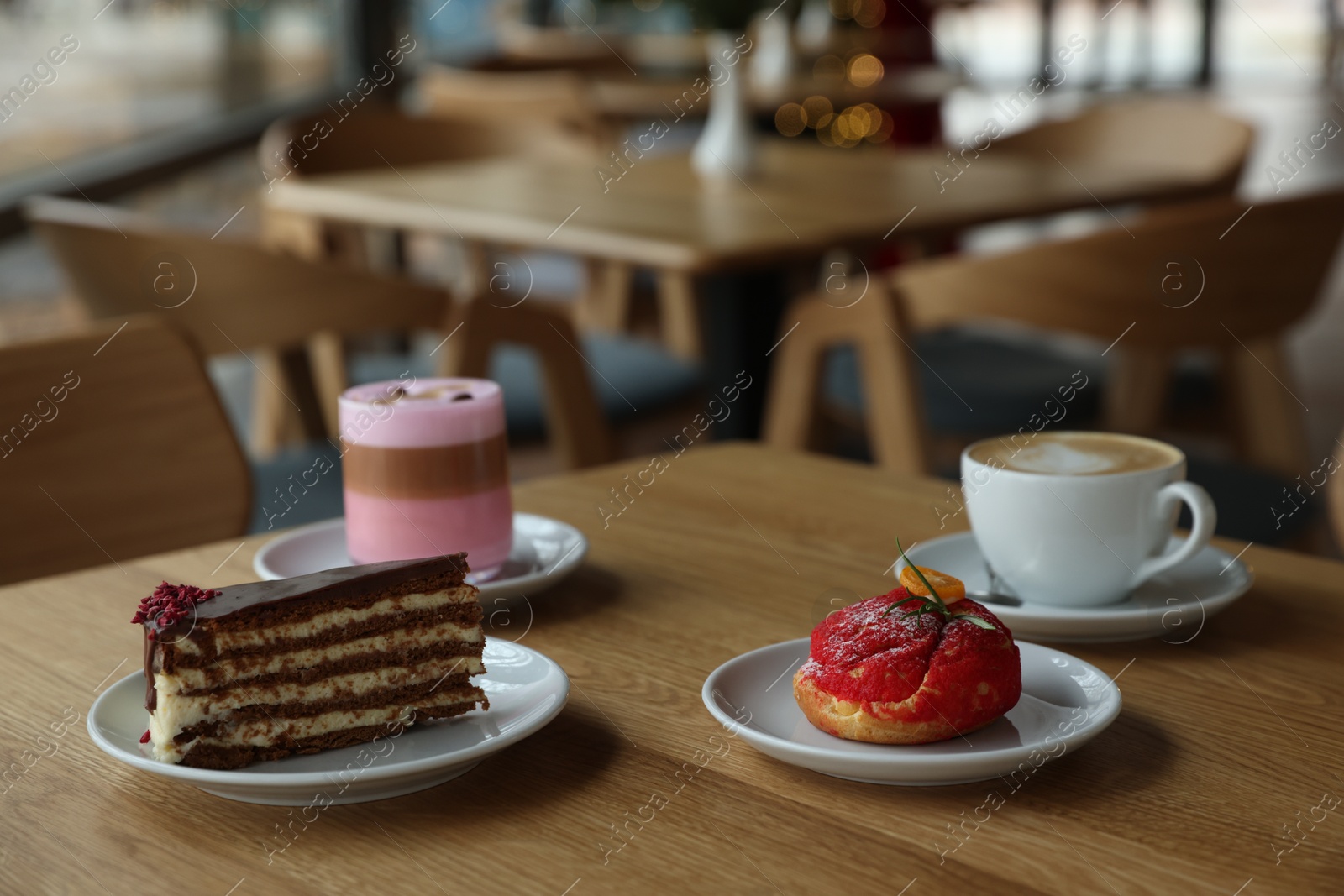 Photo of Aromatic coffee and delicious desserts served on wooden table in cafe