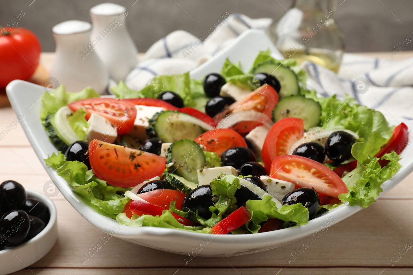 Photo of Delicious fresh Greek salad on white wooden table, closeup