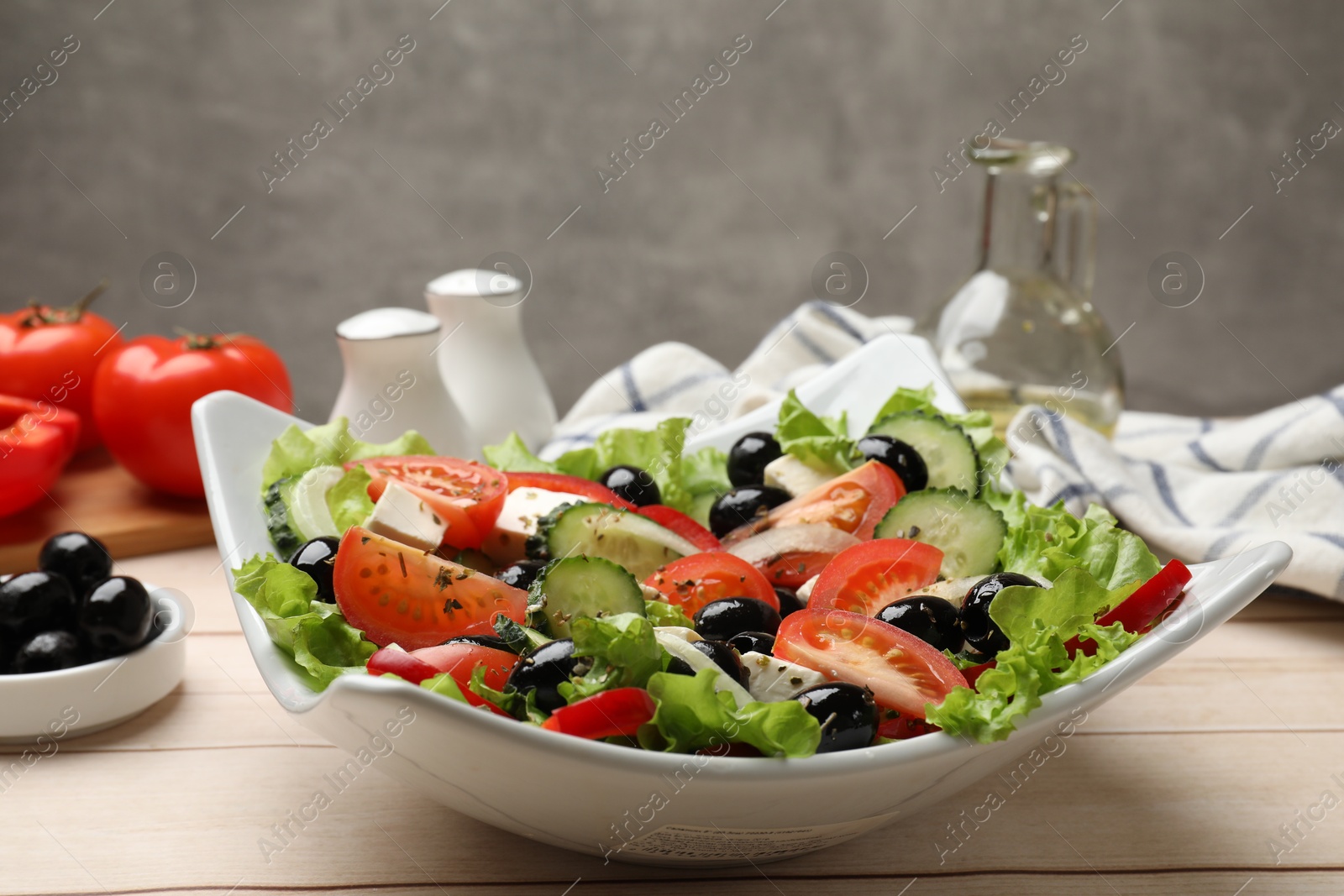 Photo of Delicious fresh Greek salad on white wooden table, closeup