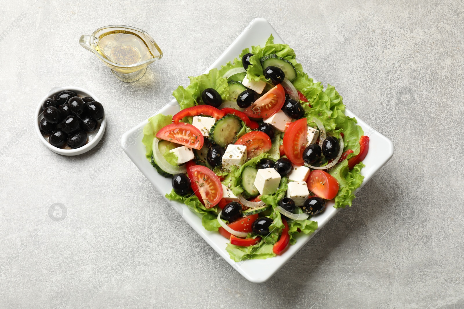 Photo of Delicious fresh Greek salad on grey table, top view