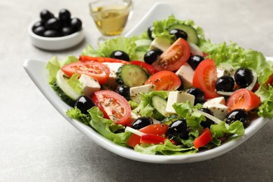 Photo of Delicious fresh Greek salad on grey table, closeup