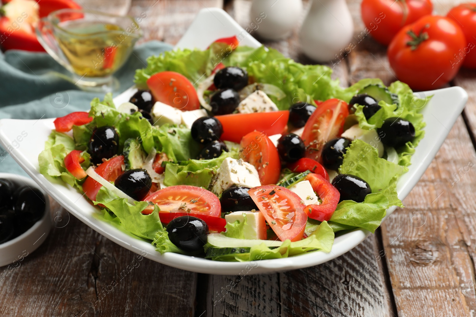 Photo of Delicious fresh Greek salad on wooden table, closeup