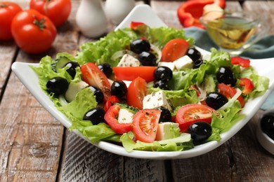 Photo of Delicious fresh Greek salad on wooden table, closeup