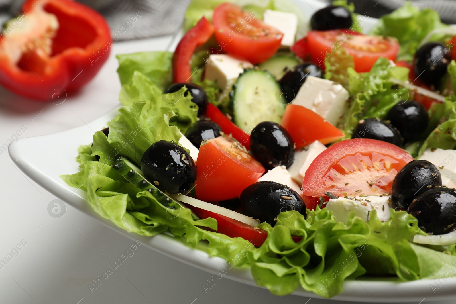 Photo of Delicious fresh Greek salad on white table, closeup