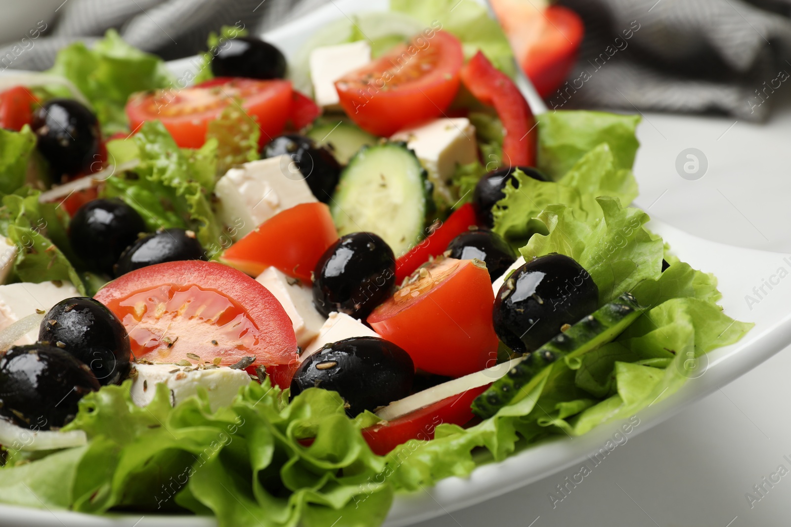 Photo of Delicious fresh Greek salad on white table, closeup