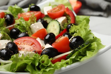 Photo of Delicious fresh Greek salad on white table, closeup