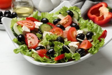 Photo of Delicious fresh Greek salad on white table, closeup