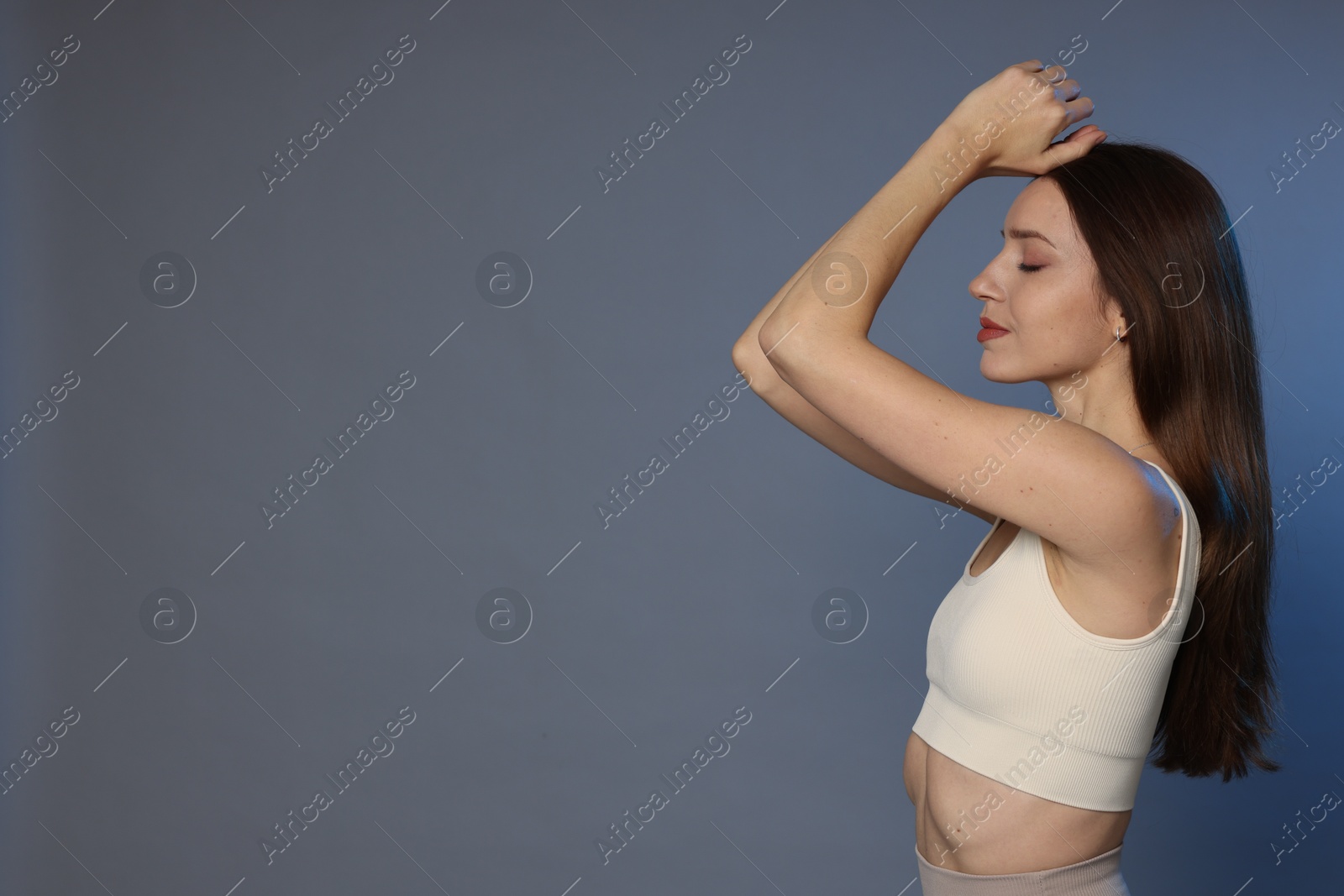 Photo of Beautiful woman in stylish sportswear on grey background. Space for text