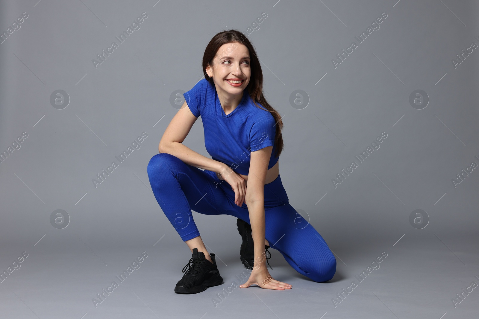 Photo of Beautiful woman in stylish sportswear on grey background