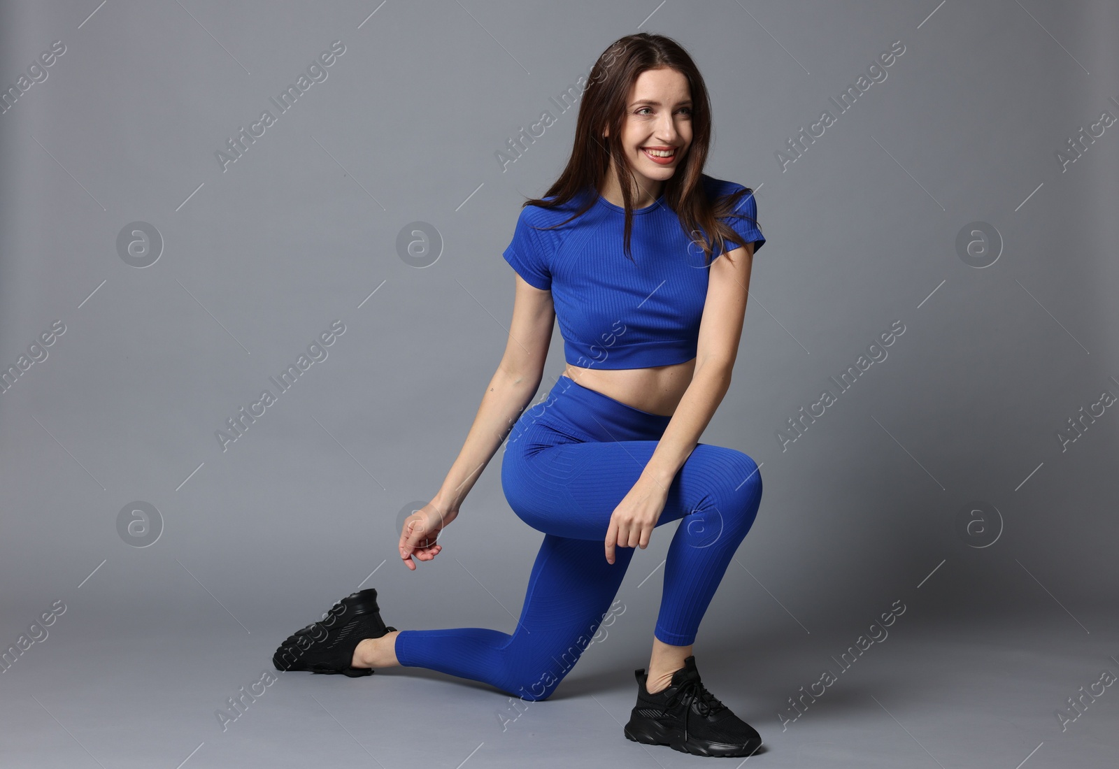 Photo of Beautiful woman in stylish sportswear on grey background