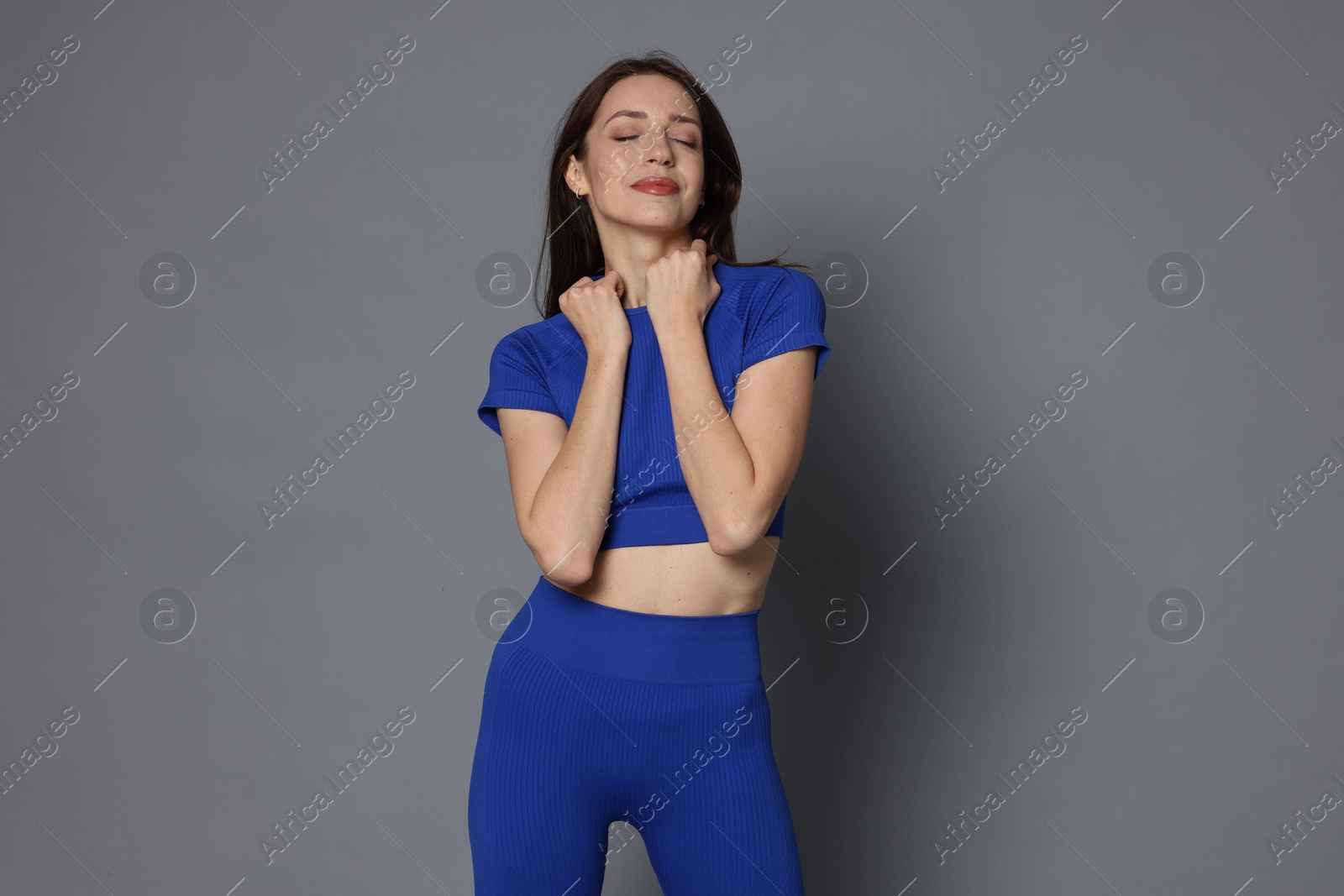 Photo of Beautiful woman in stylish sportswear on grey background