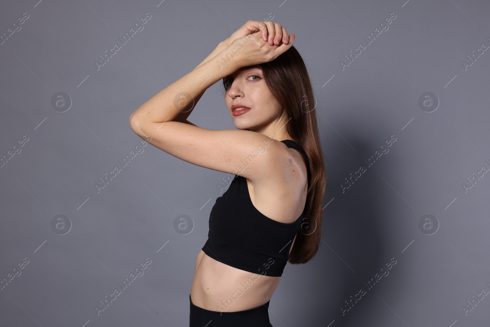 Photo of Beautiful woman in stylish sportswear on grey background