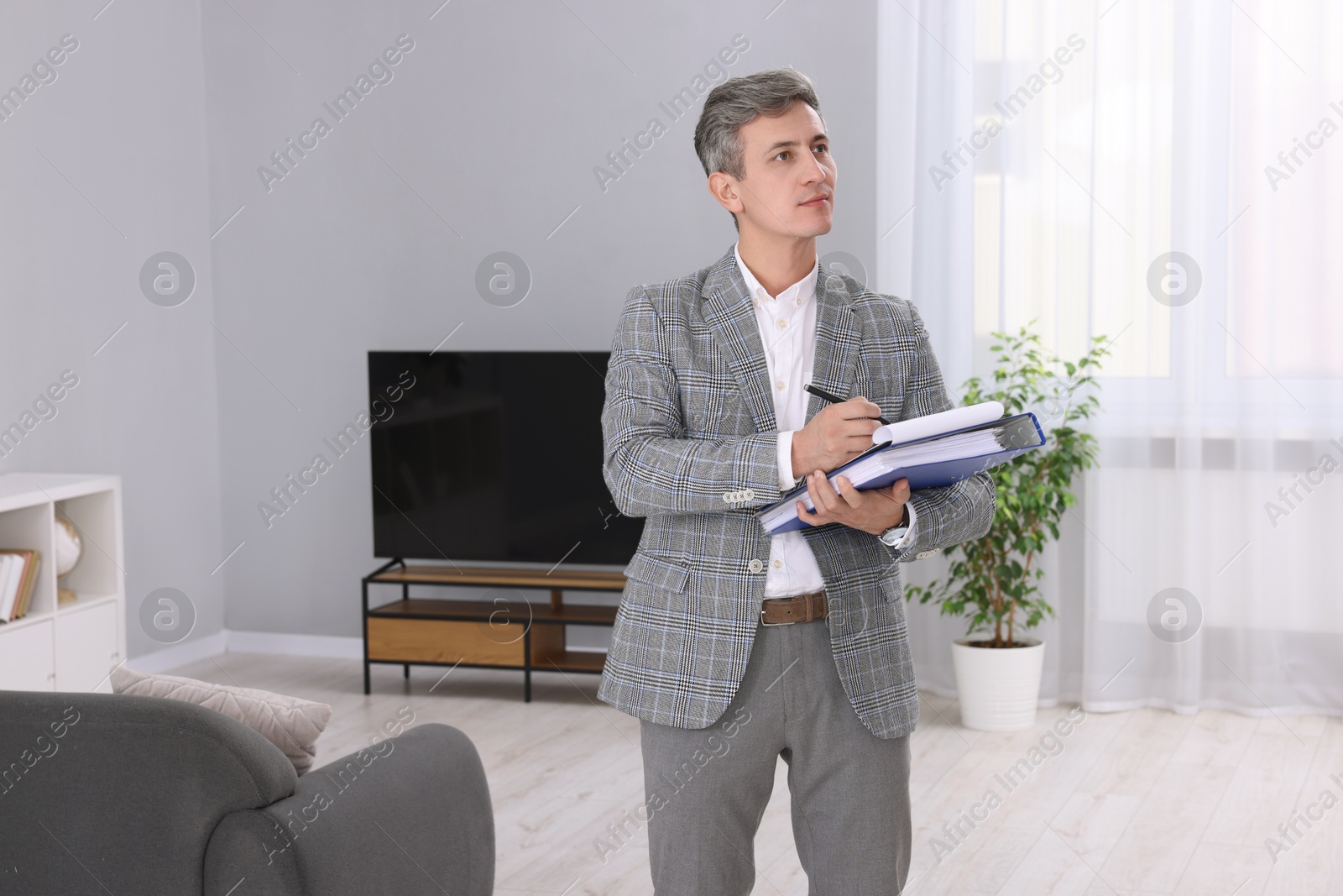 Photo of Real estate appraisal. Inspector with clipboard conducting property valuation at home