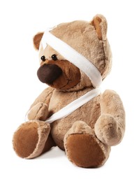 Photo of Teddy bear with bandages and adhesive medical plasters isolated on white