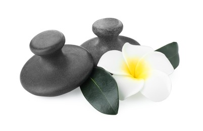 Photo of Spa stones, plumeria flower and green leaves isolated on white