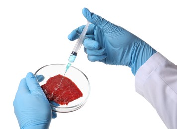 Photo of GMO concept. Scientist injecting something into piece of meat on white background, closeup