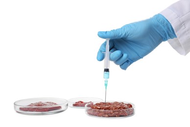 Photo of GMO concept. Scientist injecting something into minced meat on white background, closeup