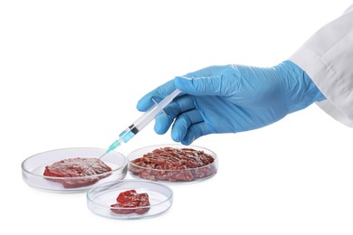 Photo of GMO concept. Scientist injecting something into minced meat on white background, closeup