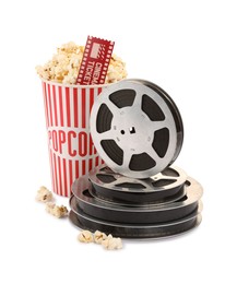 Photo of Tasty popcorn, film reels and movie ticket isolated on white