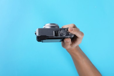 Photo of Photographer with vintage camera on light blue background, above view