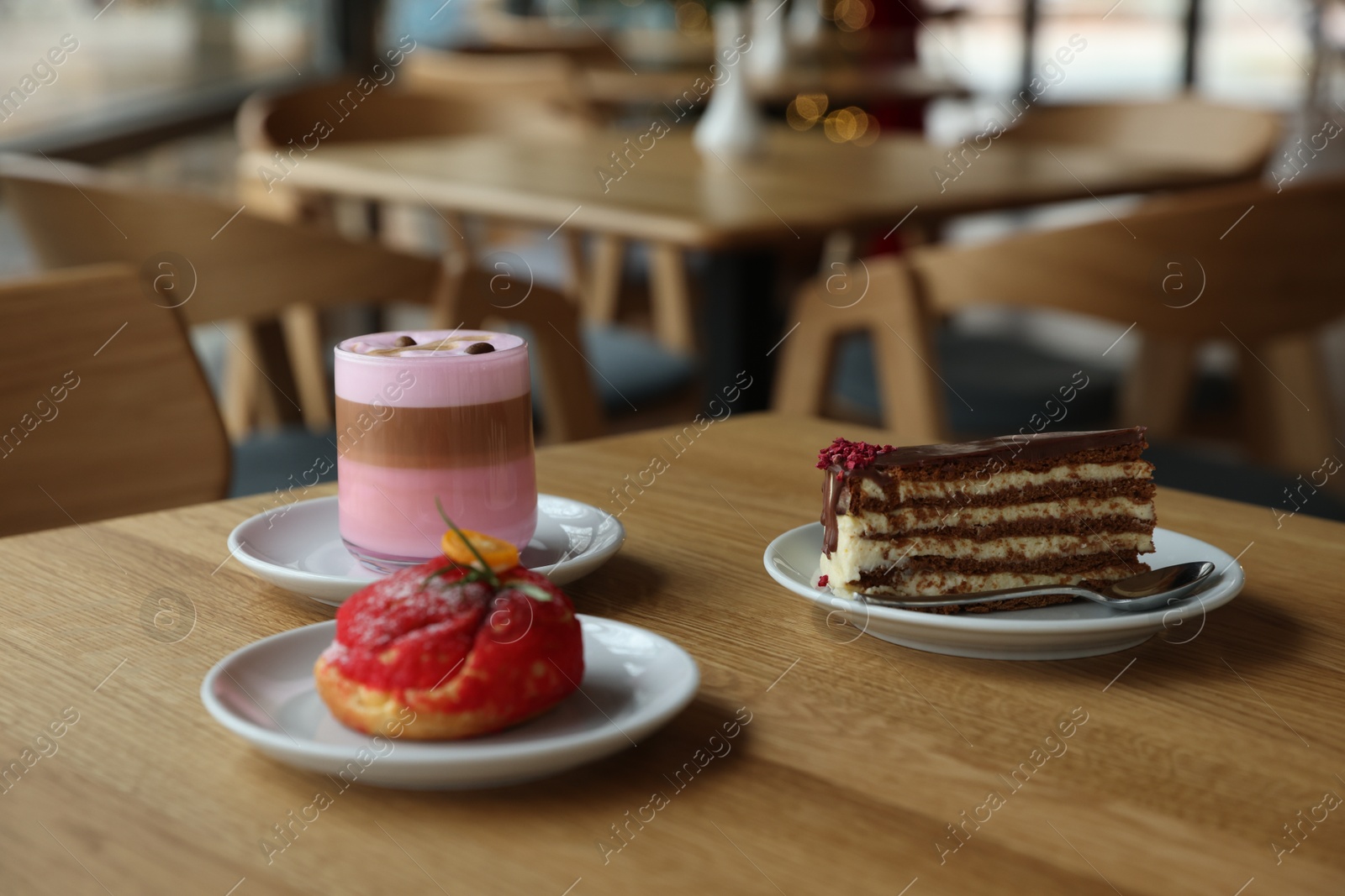 Photo of Aromatic coffee and delicious desserts served on wooden table in cafe